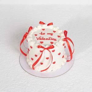 Be My Valentine red ribbon cake with white frosting and red hearts